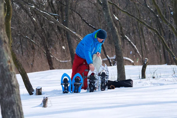 Caminante se encuentra en un bosque de invierno y la preparación de raquetas de nieve y otros — Foto de Stock