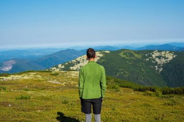 Uzun yürüyüşe çıkan kimse, genç adam dağlarda güneşli sabah saat standları