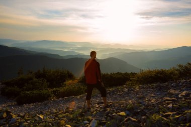 Uzun yürüyüşe çıkan kimse, adam uçurumun kenarında duruyor.