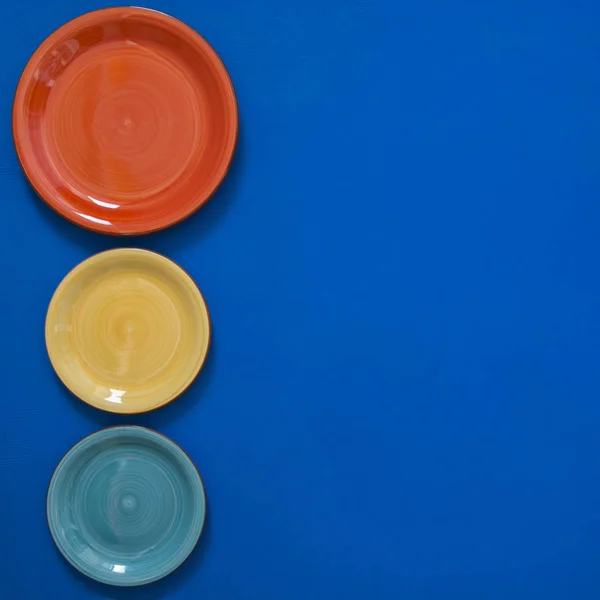 Naturaleza muerta - platos rojos, turquesa y amarillo en el borde de una b — Foto de Stock