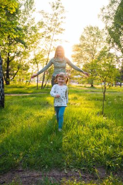 Neşeli genç anne ve küçük gurur kızı yürüyor 