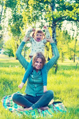 Neşeli genç anne ve komik küçük kızı eğleniyor musun
