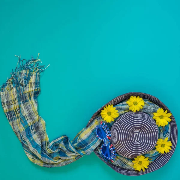 Pláž blue klobouk zdobený legrační brýle, žluté květy — Stock fotografie