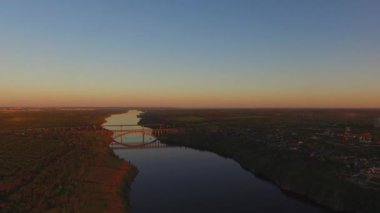 Ormanlık kıyı şeridi günbatımı sırasında büyük bir şehir yanındaki büyük bir Nehri Panoraması. Dinyeper Nehri, Zaporozhye, Ukrayna. Havadan görünümü.