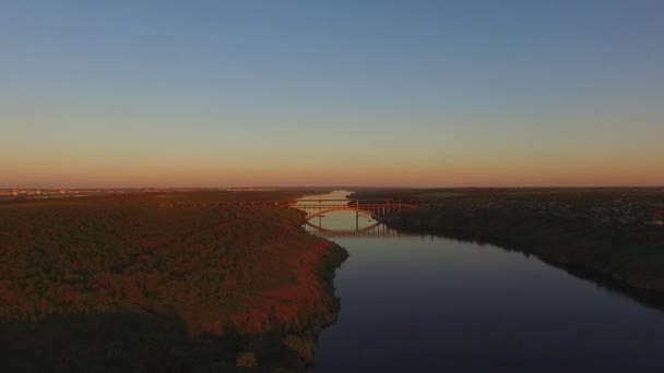 在日落期间 沿着一座大城市旁边的一条大河的树木繁茂的海岸线飞行 第聂伯河河 扎波罗热 乌克兰 — 图库视频影像