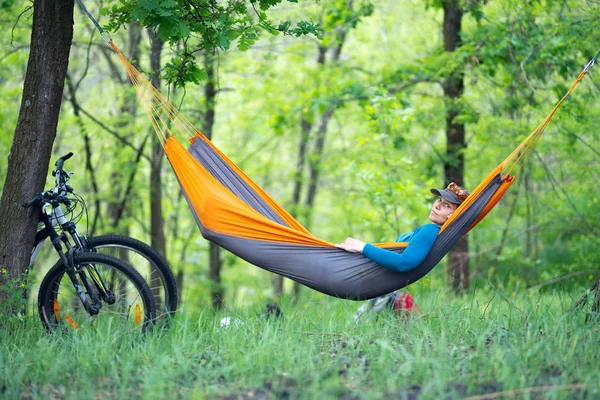 Mujer se relaja en una hamaca después de andar en bicicleta — Foto de Stock