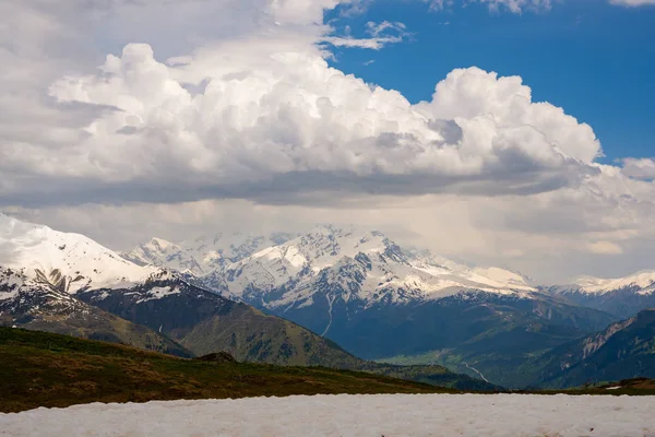 Lage wolken drijven tussen de besneeuwde bergketens — Stockfoto