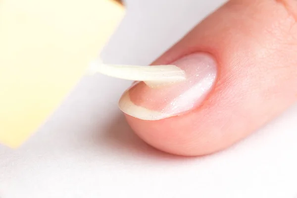 Master of manicure covers customer nails clear varnish with spar — Stock Photo, Image