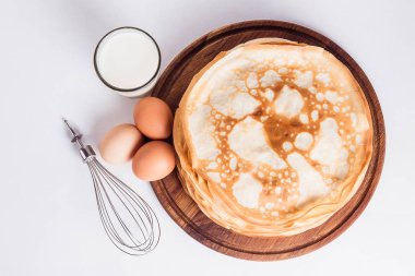 Bir yuvarlak ahşap stand ingredien bir çırpma teli ile ince krep