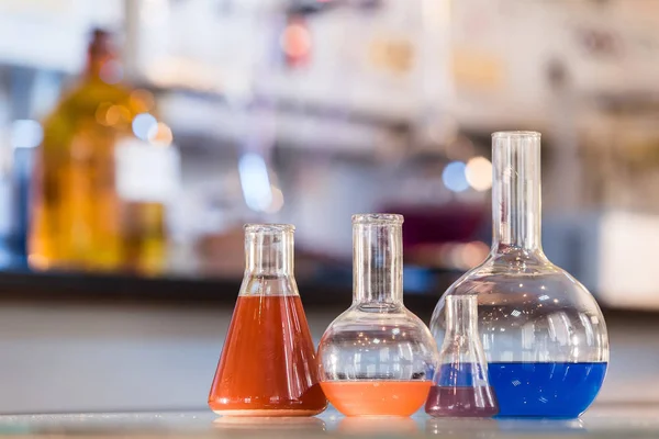 Bekerglas met kleurrijke vloeistof in het laboratorium — Stockfoto