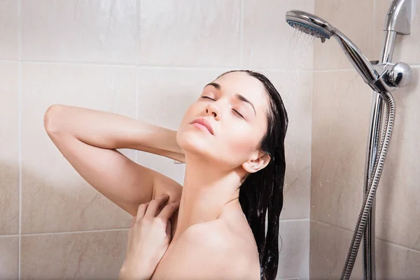 Jeune femme se lave la tête sous la douche — Photo