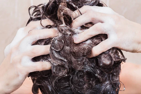 Mujer joven lavando el cabello con champú en la ducha — Foto de Stock