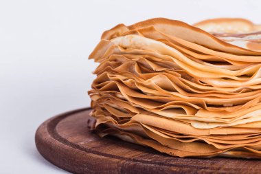 Beyaz zemin üzerinde bir yuvarlak ahşap stand ince krep 