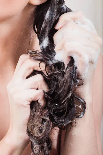 Mujer joven lavando el cabello con champú en la ducha — Foto de Stock