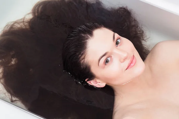 Junge Frau im Badezimmer, um Haare unter Wasser zu spülen — Stockfoto