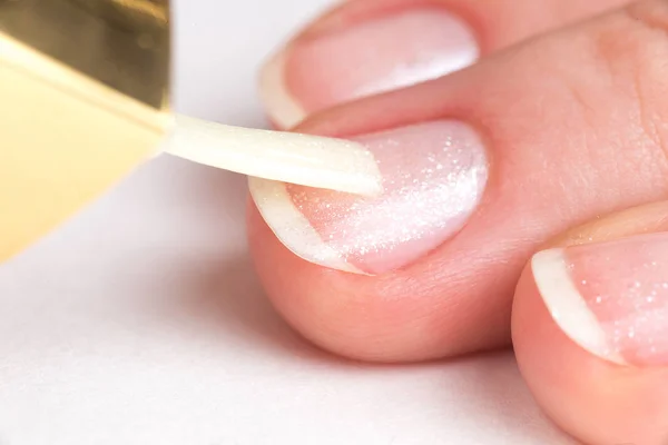 Master of manicure covers customer nails clear varnish with spar — Stock Photo, Image