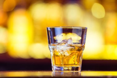 Çubuğu'nda bir bardak buzlu bir viski (portre). Traditiona