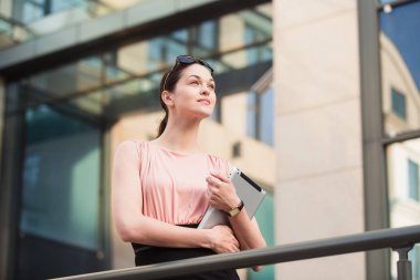Açık havada office yakınındaki tablet ile çalışan iş kadın