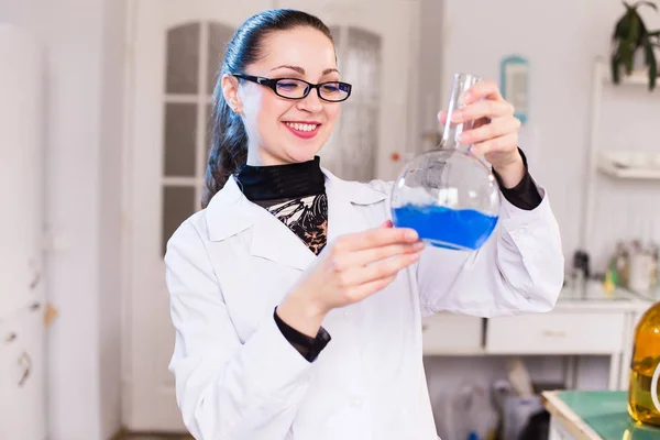 Вчений в лабораторії, що вивчає рідину в склянці — стокове фото