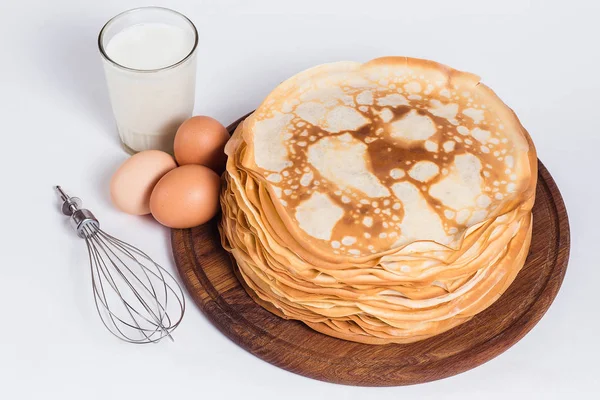 Panquecas finas em um carrinho de madeira redondo com um batedor e ingrediente — Fotografia de Stock