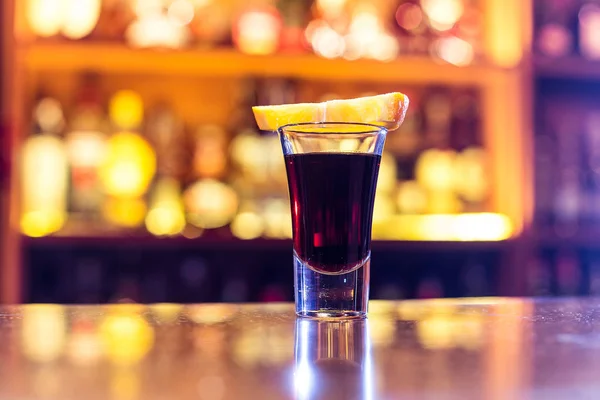 Svart cocktail i en stapel med en skiva apelsin — Stockfoto