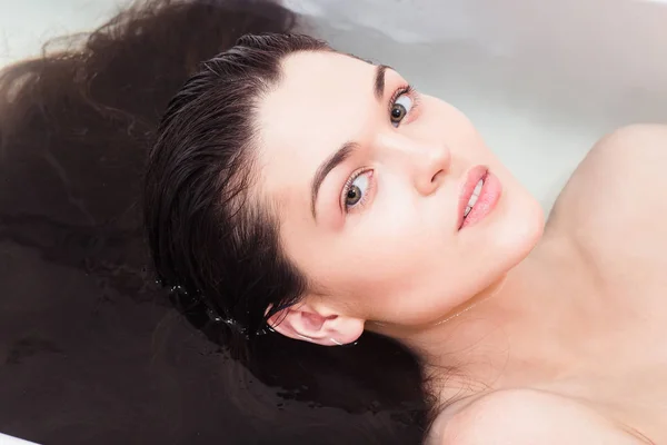 Junge Frau im Badezimmer, um Haare unter Wasser zu spülen — Stockfoto