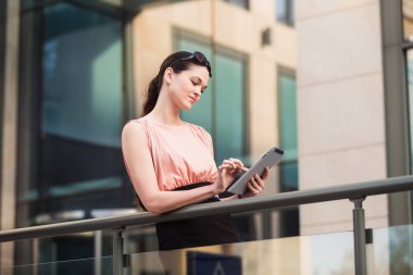 Açık havada office yakınındaki tablet ile çalışan iş kadın