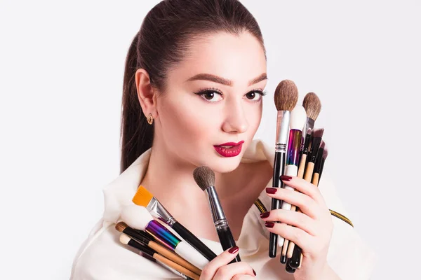 Make-up kunstenaar met penselen in de hand op een witte achtergrond — Stockfoto