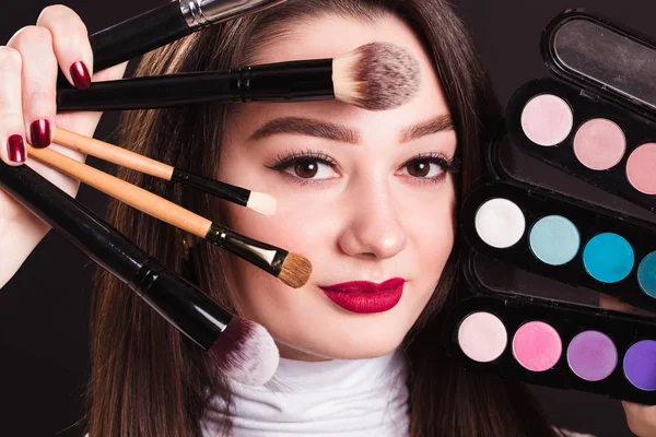 Лицо красивой девушки с кисточками для макияжа и глаз — стоковое фото