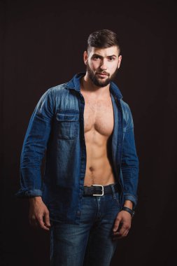 Bir sakallı genç yakışıklı kaslı adam siyah arkasında poz