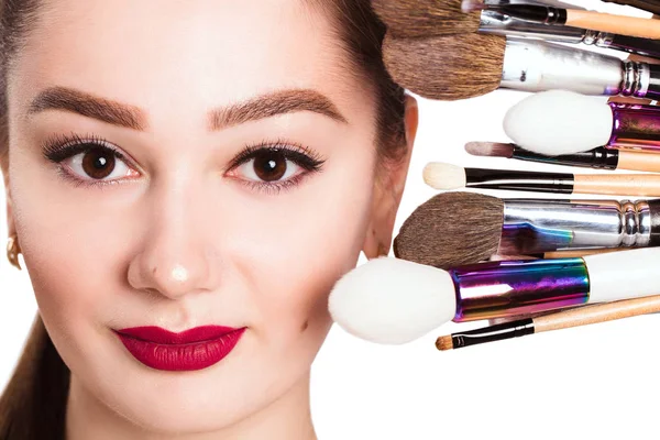 Het gezicht van een mooi meisje en make-up borstel op witte CHTERGRO — Stockfoto