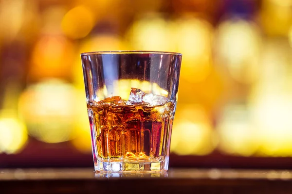 Un whisky con hielo en un vaso en la barra (primer plano). Traditiona — Foto de Stock