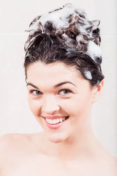 年轻女子在洗澡洗头发的洗发水 — 图库照片