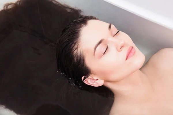 Jeune femme dans la salle de bain pour rincer les cheveux sous l'eau — Photo