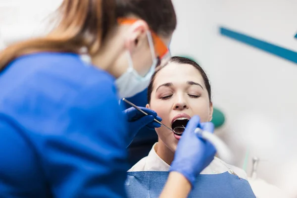 El paciente en el consultorio dental realiza un procedimiento doloroso — Foto de Stock