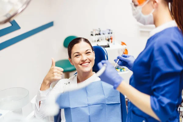 Chica paciente sonriendo en la silla del dentista —  Fotos de Stock