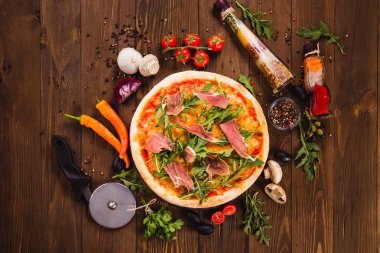 Pastırma ve roka malzemeler (en iyi Görünümü Kapat çevresinde koyu bir ahşap zemin üzerine pizza).