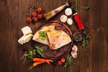 Geleneksel İtalyan Pizza koyu ahşap arka plan (en iyi Görünümü Kapat üzerinde malzemelerle 