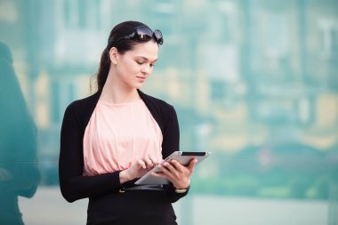 Açık havada office yakınındaki tablet ile çalışan iş kadın