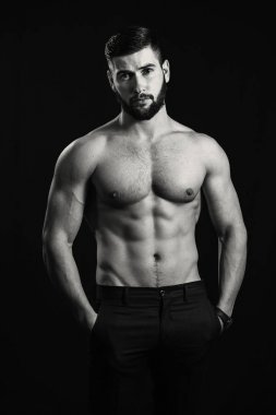 Bir sakallı genç yakışıklı kaslı adam siyah arkasında poz