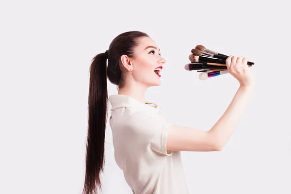 Визажист держит кисти для макияжа в качестве микрофона на — стоковое фото