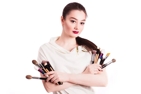 Make-up kunstenaar met penselen in de hand op een witte achtergrond — Stockfoto