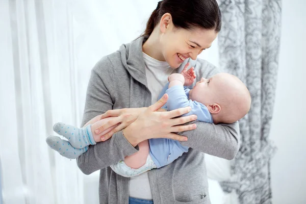 Uma Mãe Feliz Está Segurando Uma Criança Pequena — Fotografia de Stock