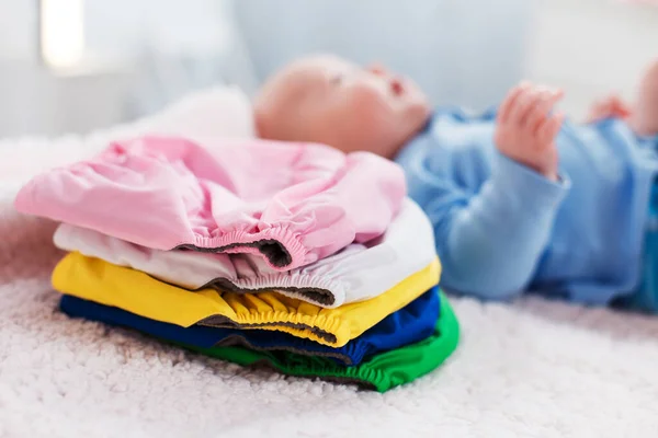 Criança Fica Perto Uma Pilha Fraldas Reutilizáveis Multicoloridas Uma Mesa — Fotografia de Stock