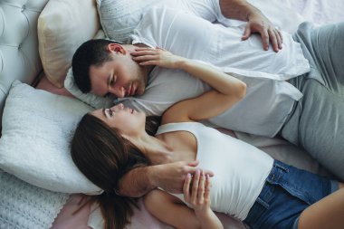 Genç aşıklar erkek ve kadın yataktaki yataktalar. Sarıl, öp..