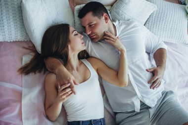 Genç aşıklar erkek ve kadın yataktaki yataktalar. Sarıl, öp..
