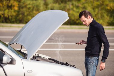 Yakışıklı genç adam yol kenarında arabası arızalanmış ve yardım istiyor.