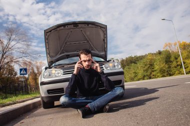 Arabasının arızası yüzünden umutsuzluğa düşmüş bir adam. 