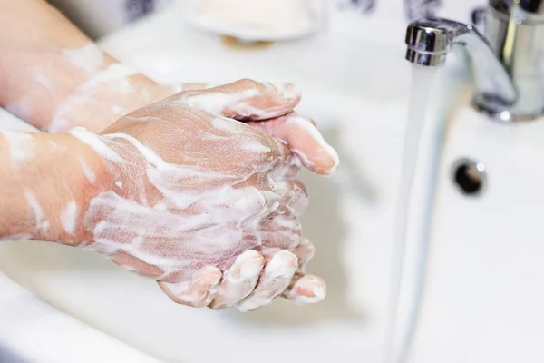 男はバスルームの石鹸で手を洗う 衛生兵だ パンデミックの際の消毒と予防策 — ストック写真