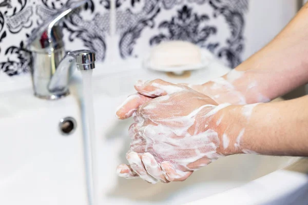 男はバスルームの石鹸で手を洗う 衛生兵だ パンデミックの際の消毒と予防策 — ストック写真
